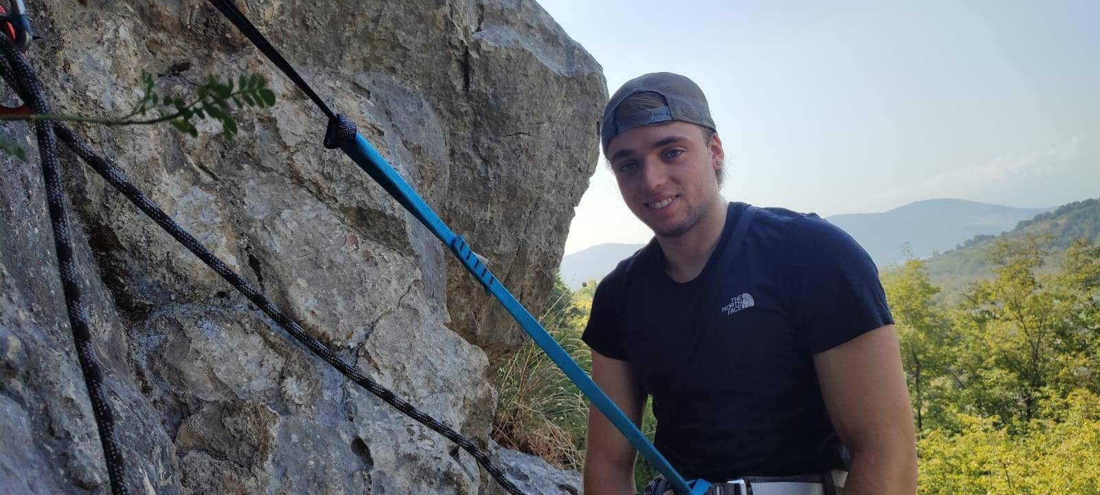 ragazzo che scala montagna